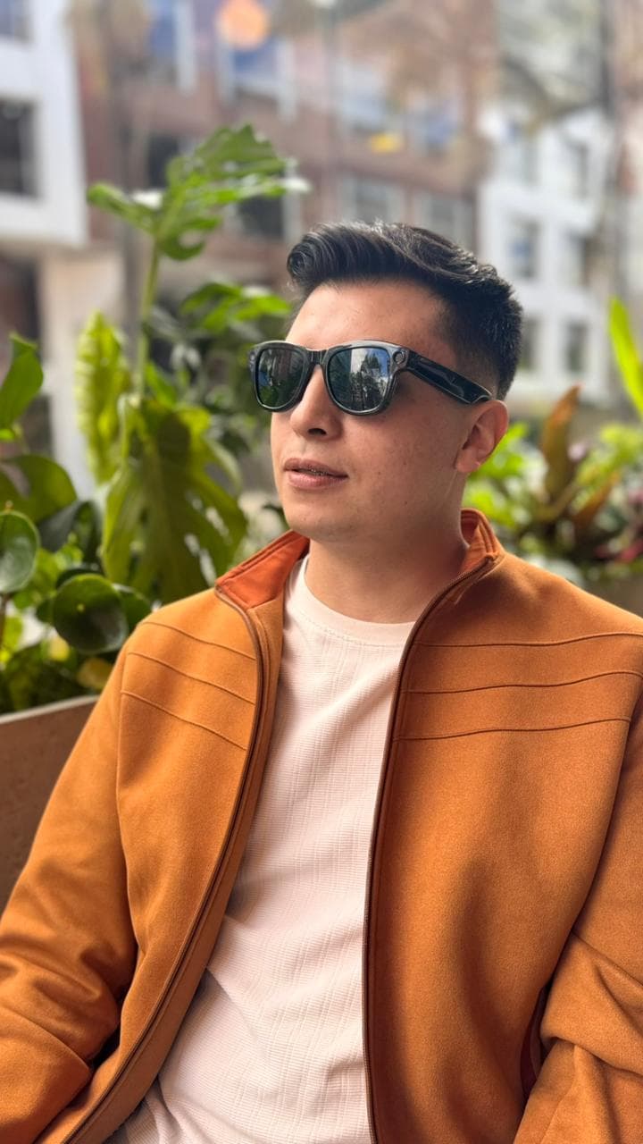 Hombre con chaqueta y gafas de sol AXIS en un balcón
